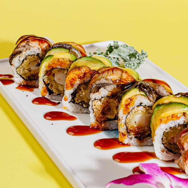 Kanpai Sushi's dragon roll with avocado, eel, and shrimp tempura, drizzled with sauce.