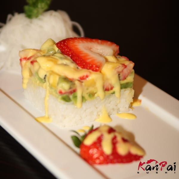Kanpai Sushi's fruit sushi with strawberries, kiwi, and mango sauce on a white plate.